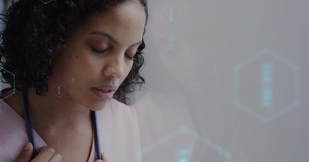 Image of network of medical icons and data processing over biracial female doctor. Global science, medicine, research, computing and data processing concept digitally generated image.の写真素材