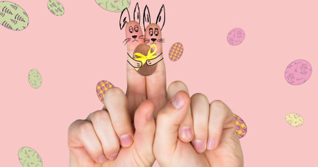 Image of hand with easter decorations and easter eggs over pink background. easter, tradition and celebration concept digitally generated image.の写真素材