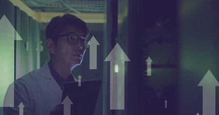 Image of white arrows over asian male it engineer with tablet checking computer servers. data...