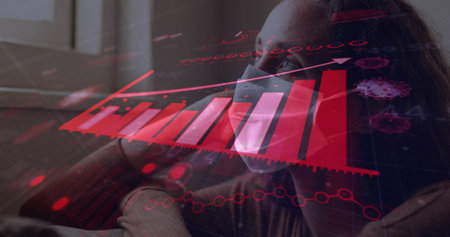 Image of digital interface with graphs and statistics over woman wearing face mask looking through window. Global coronavirus pandemic concept digitally generated image.の写真素材