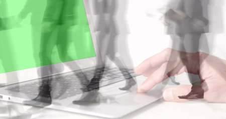 Image of hands using laptop with green screen over sped up commuters walking in modern building. business and communication technology concept digitally generated image.の写真素材