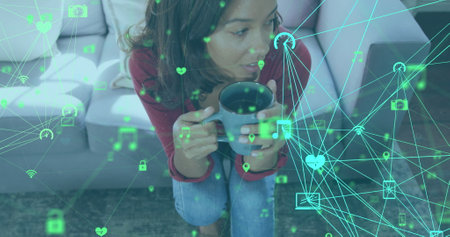Image of networks of connections with digital icons over woman using laptop at home. global social...