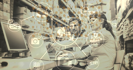 Network of digital icons over male and female supervisor using laptop at warehouse. global networking and logistics transportation business conceptの写真素材