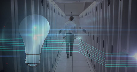 Image of lightbulb icon over caucasian man working in a server room. digital interface global...