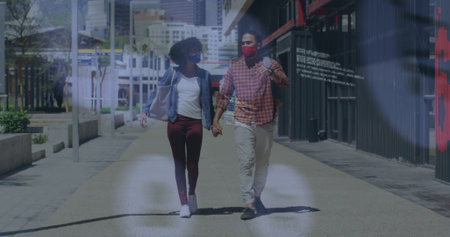 Image of social media icons over african american couple holding hands walking on the street. Social media networking technology conceptの写真素材