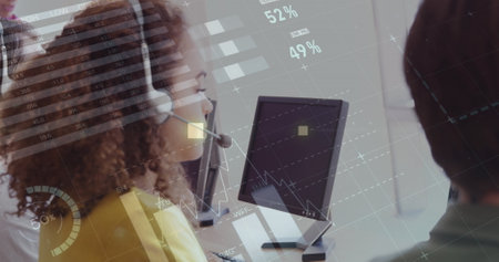 Image of financial graphs and data over happy biracial call center worker. Business, call center, finance, economy and working with technology concept digitally generated image.の写真素材