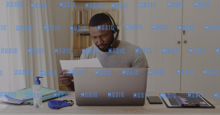 Image of music text over african american man in phone headset using laptop. Global business and...