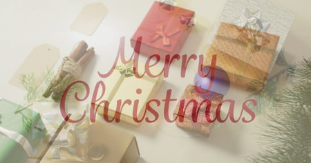 Image of christmas greetings text over christmas presents and decorations. Christmas, festivity, celebration and tradition concept digitally generated image.の写真素材