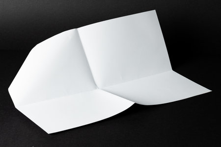A blank tri-fold brochure mockup on a black background with copy space. Ideal for presenting design work or marketing materials, the layout allows for easy customization.の写真素材