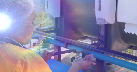 Image of lights and lens flare over african american woman washing hands outdoors at standpipe....