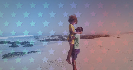 Young African American couple embraces on a star-patterned beach. The playful lift suggests a moment...