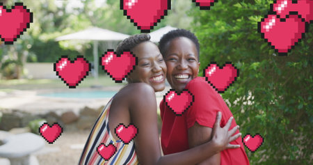 Image of hearts over smiling african american mother and daughter in garden. family life, love and nature concept digitally generated image.の写真素材