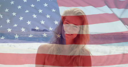 Image of flag of usa over caucasian woman on beach in summer. Usa, american patriotism, national flag and lifestyle concept digitally generated image.の写真素材