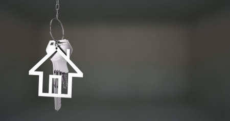 House-shaped keychain image over blurred background. Real estate, home, keyring, keys, housewarming, digitalの写真素材