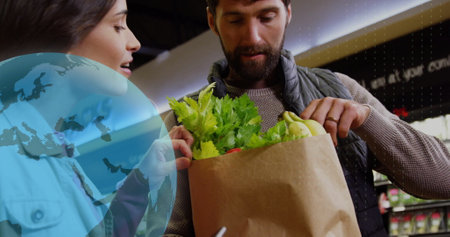 Image of data processing with icons over caucasian couple grocery shopping. Global shopping, business, connections, computing and data processing concept digitally generated image.の写真素材