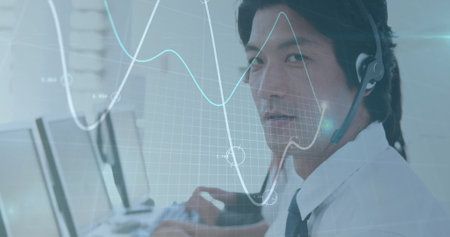 Image of financial data processing over asian businessman using phone headset and computer. Global...