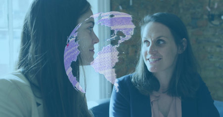 Digital globe image over two businesswomen having conversation in office. technology, professional,...