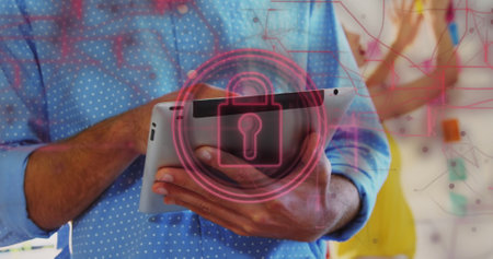 Image of security padlock and connections over biracial businessman using tablet in office. Global online security, business, cloud computing and data processing concept digitally generated image.の写真素材