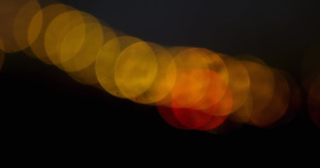 Image of moving spots of yellow light on black background 4kの写真素材