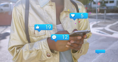 Image of social media reaction over hands of afrcian american woman using smartphone. Social media,...
