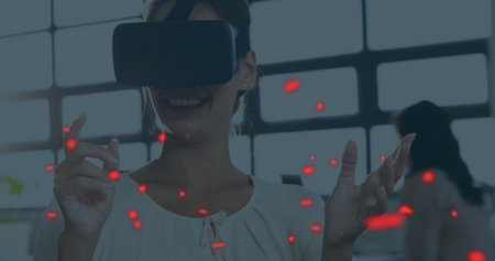 Caucasian woman in VR headset using digital interface. She has light brown hair, wearing simple blouse, enjoying technologyの写真素材