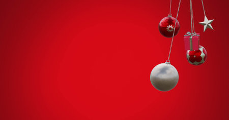 Image of hanging baubles, star and gift box swinging against red background. Digitally generated, hologram, illustration, decoration, christmas, holiday, winter and celebration concept.の写真素材
