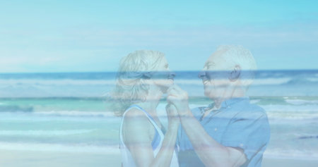 Image of landscape with ocean over happy senior caucasian couple dancing at beach. ocean day and...