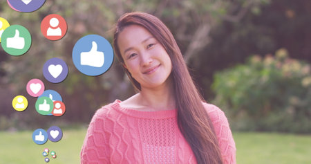 Image of hearts over asian smiling woman. social media and communication interface concept digitally...