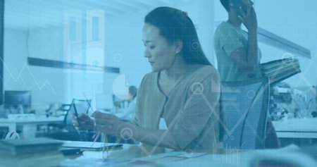 Image of data processing and digital icons over asian woman taking notes at office. Computer...