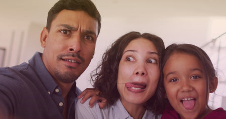 Image of bokeh over happy biracial family making funny faces. family, relationship and spending quality time together concept digitally generated image.の写真素材