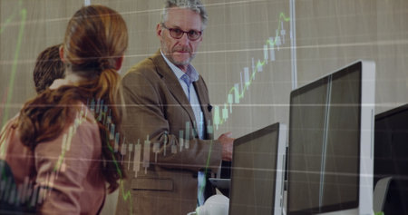 Image of financial data processing over diverse business people at office. Global finances, business and digital interface concept digitally generated image.の写真素材