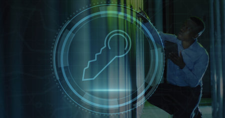 Image of security key icon over african american male engineer using tablet at server room. Cyber...