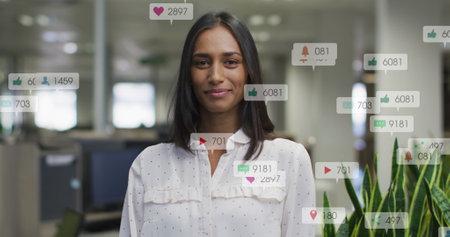 Image of changing numbers, icons in notification bars, smiling biracial woman standing in office....