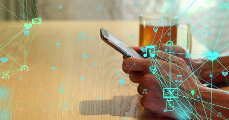 Image of network of connections with icons over biracial businesswoman using smartphone. Global...