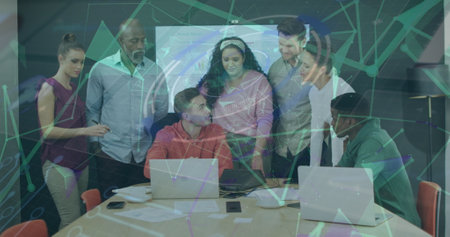 Image of plexus networks over team of diverse colleagues discussing over a laptop at office. Global networking and business technology conceptの写真素材