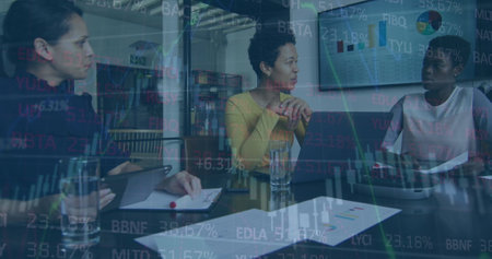 Image of graphs and trading board over diverse female coworkers discussing report on laptop. Digital...