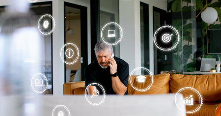 Image of digital icons with data processing over caucasian businessman in office. Global business, finances, computing and data processing concept digitally generated image.の写真素材