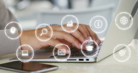Image of digital icons over biracial businesswoman using laptop in office. Global business,...