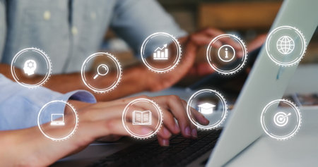 Image of multiple icon in circles over diverse coworkers using laptop and cellphone in office....