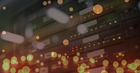 Image of computer language and falling lens flares over multiple modems in background. Digital...