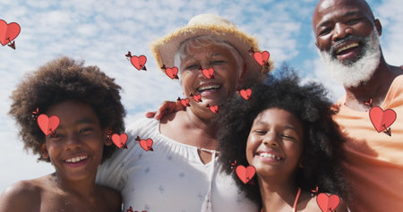 Image of hearts over smiling african american family smiling and embracing. family spending time together concept digitally generated image.の写真素材