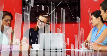 Image of financial data processing over diverse business people using laptop. global business, finance, data processing and digital interface concept digitally generated image.の写真素材