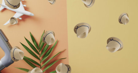 Image of sunhats falling over plane model on yellow background. Lifestyle and travel concept...