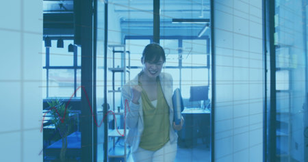 Image of financial graphs and data over happy asian woman in office. Business, finance and economy...