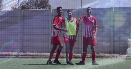 Image of interface processing data over biracial male footballers celebrating on pitch. Sports, competition, fitness and technology concept digitally generated image.の写真素材