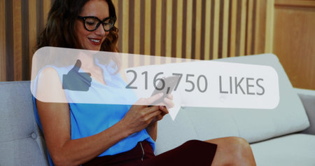 Image of social media like notification over smiling caucasian woman using smartphone. Global...