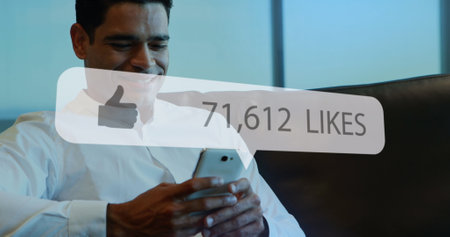Image of social media likes notification over smiling asian man using smartphone. Global communication network, business and social media concept digitally generated image.の写真素材