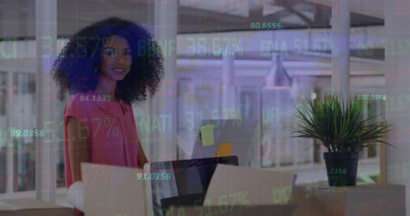 Image of stock market data processing over african american woman using computer at office. Global economy and business technology conceptの写真素材