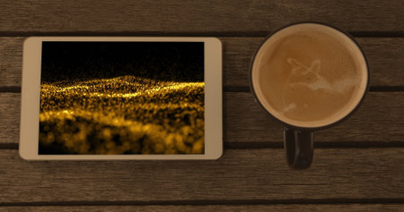 Image of smartphone with light trails on screen and cup of coffee on desk. Global technology, abstract background and digital interface concept digitally generated image.の写真素材