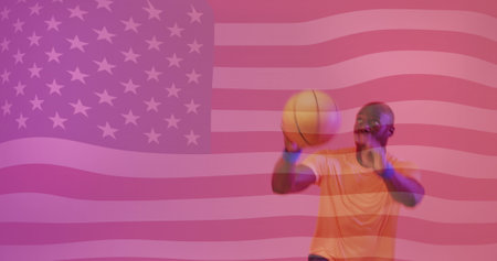 Image of flag of america over african american male basketball player jumping with ball. Sport, competition, flag, identitity, nationality and patriotism digitally generated image.の写真素材